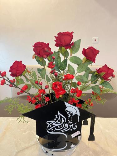 F103 قبعة تخرج من الأكريليك الأسود مزينة بأزهار حمراء