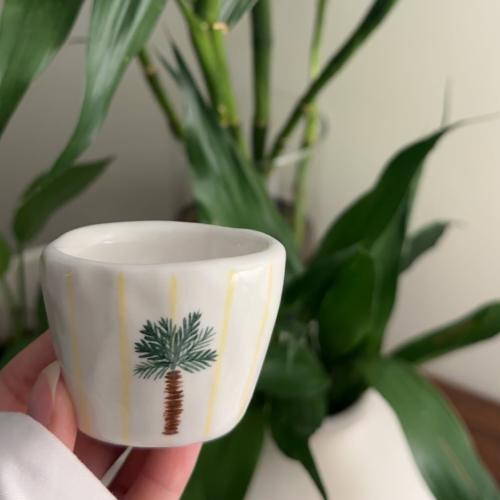 فنجان قهوة نخيل من قدام مخطط اصفر