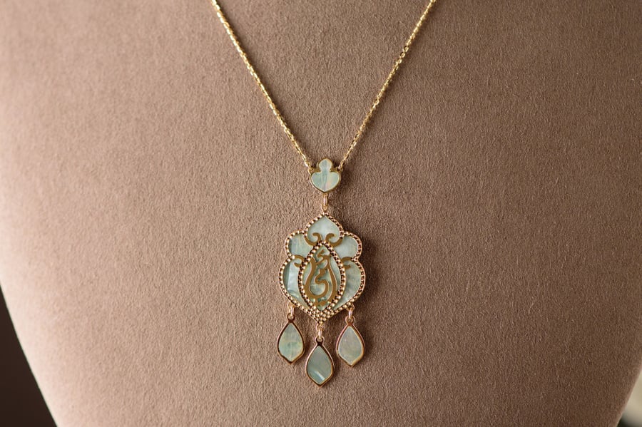A long necklace of 18 karat gold sweetened with mother of pearl and engraved with the word (my mother)