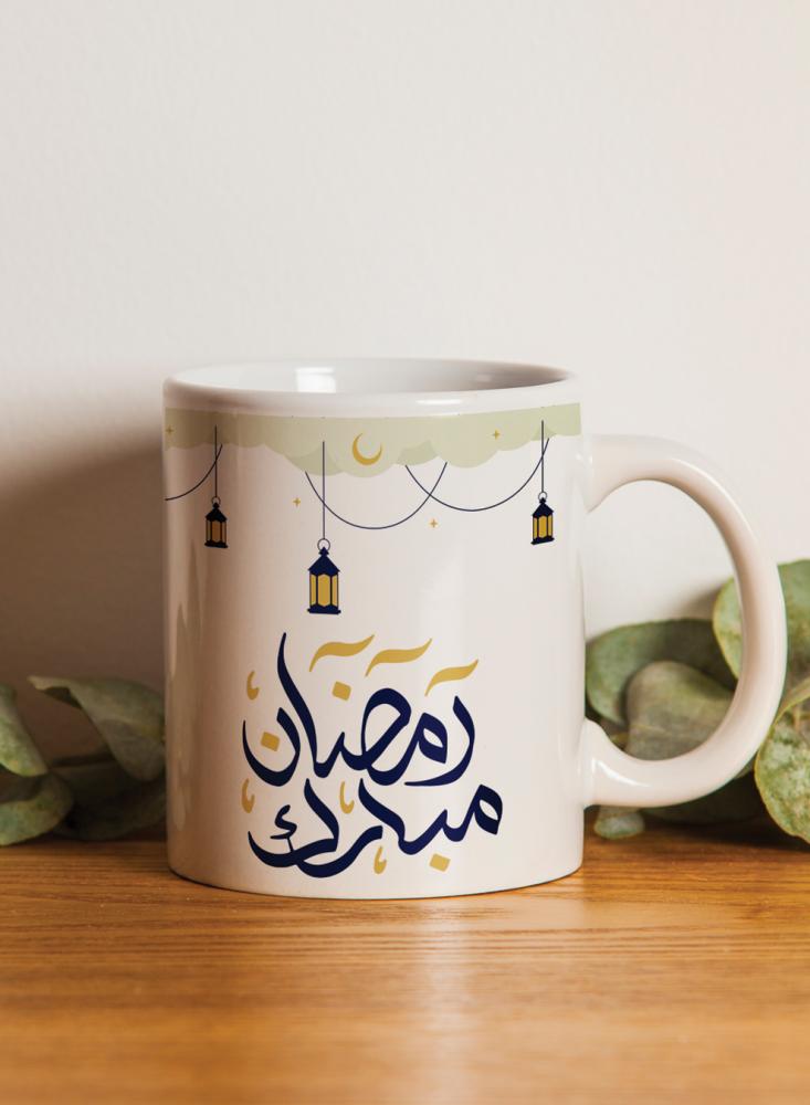 A 11-ounce ceramic cup with a Ramadan Mubarak design and lanterns