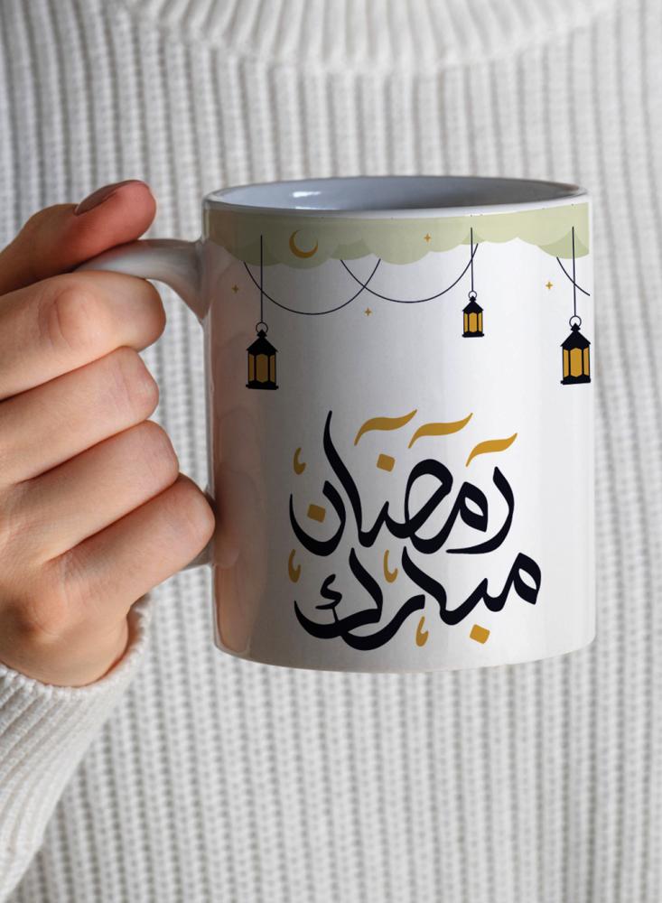 A 11-ounce ceramic cup with a Ramadan Mubarak design and lanterns