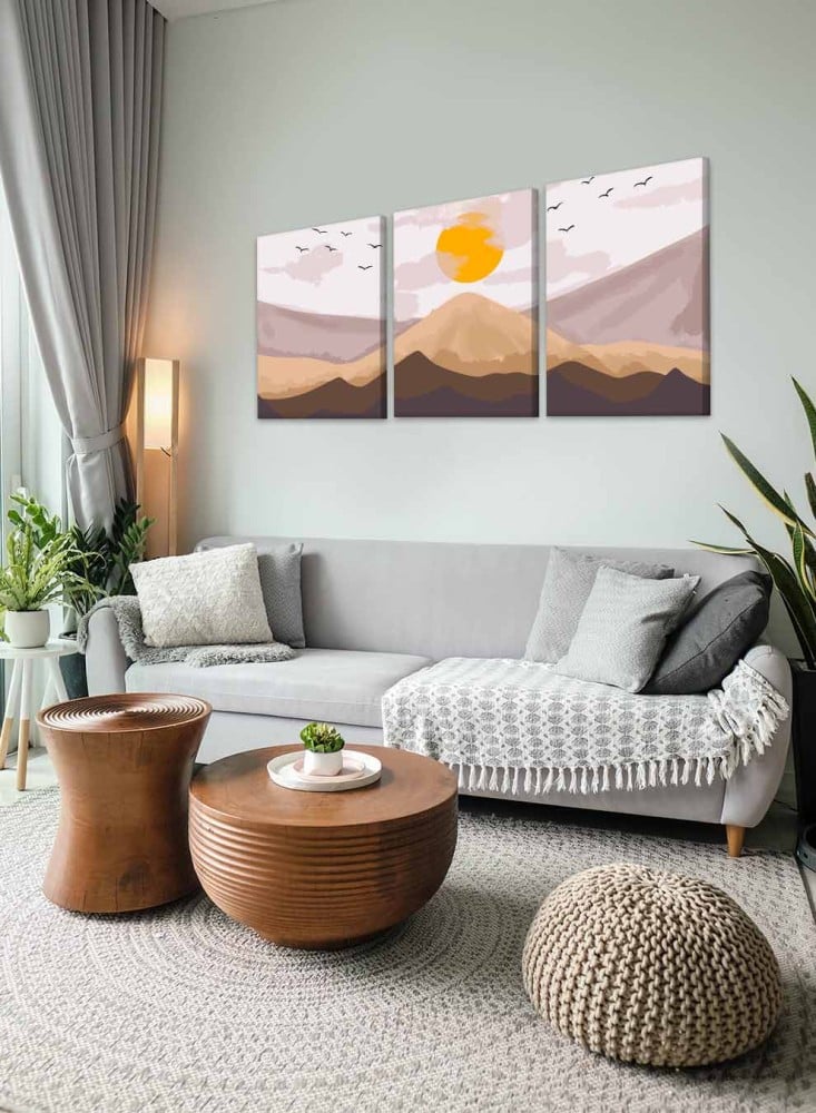 A set of 3 canvas panels on a wooden frame with an abstract art design of sunrise over the mountain