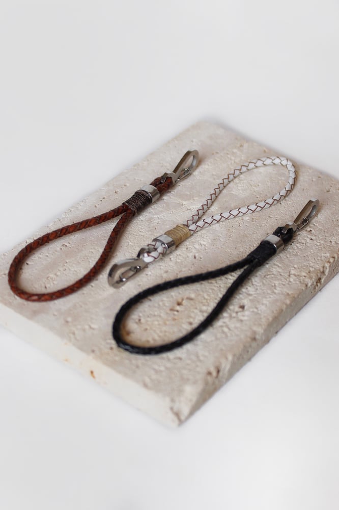 A thin brown medal made of braided leather
