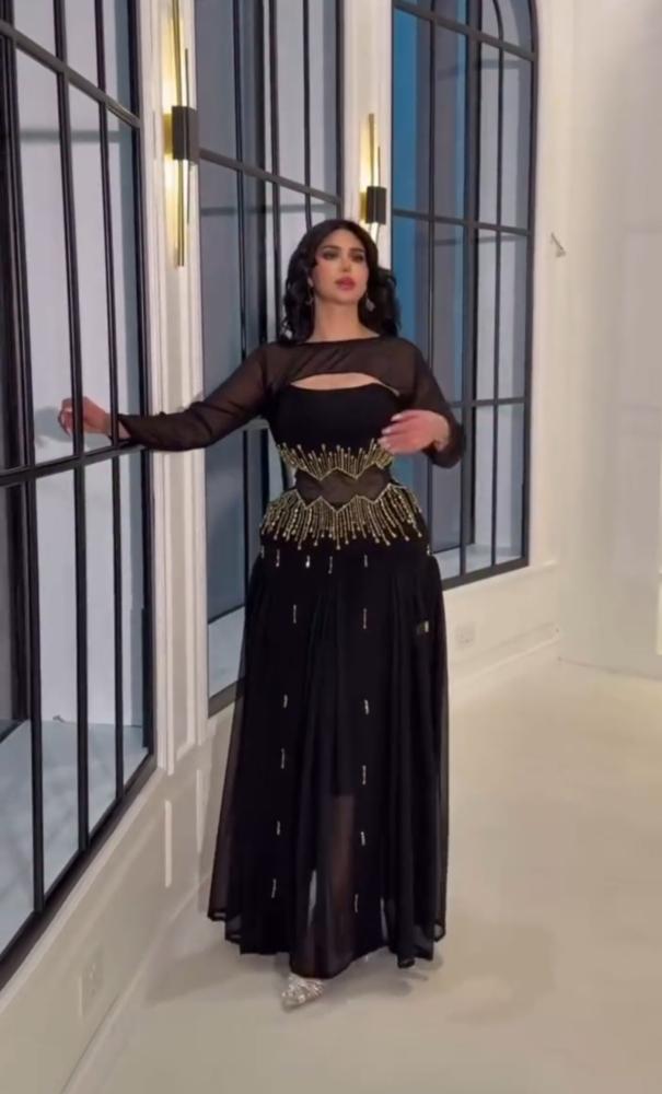 فستان سهرة أسود بتفاصيل تطريز ذهبية على الخصر