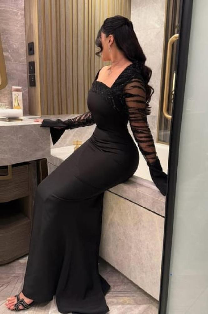 فستان سهرة أسود بأكمام شفافة مزينة بالترتر