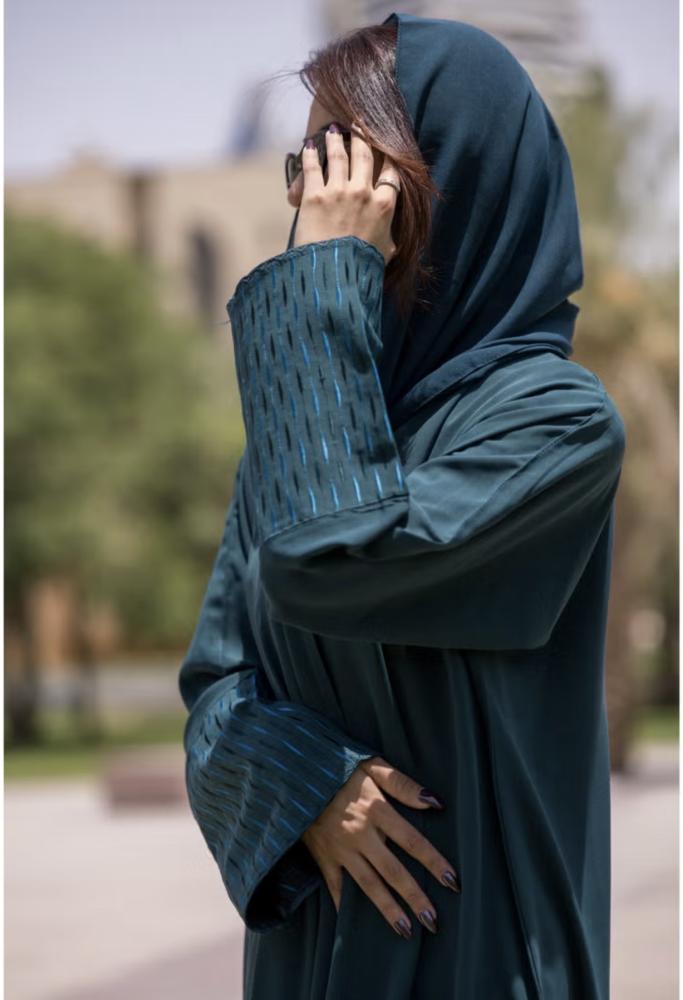 عباية بتصميم فريد بياقة على شكل حرف  وأكمام مطرزة باللون الأزرق المخضر