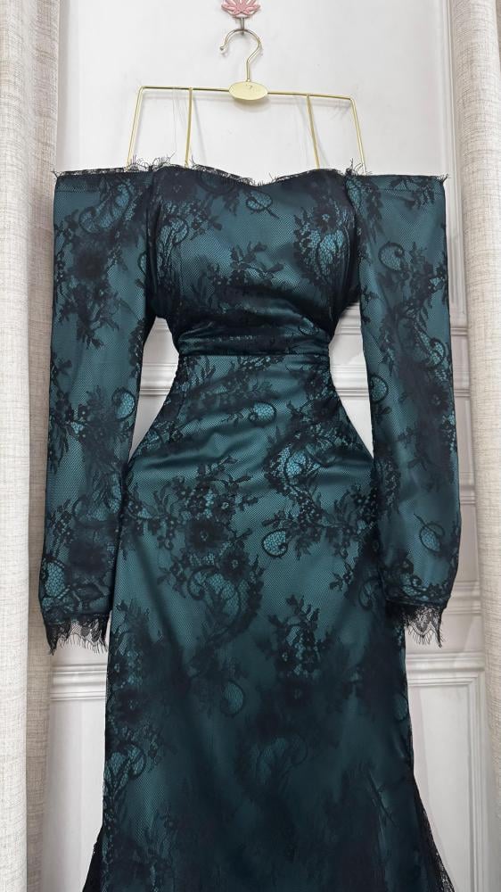 Lamis dress. Soft green lace that overflows with femininity and elegance, characterized by its delicate patterns and light touch that drapes smoothly over the figure. Its calm green color gives a feeling of freshness and sophistication, providing a soft a