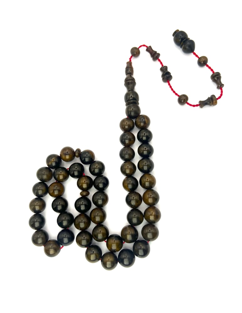 An olive-colored Fatoran prayer bead rosary, with a Tamlikah