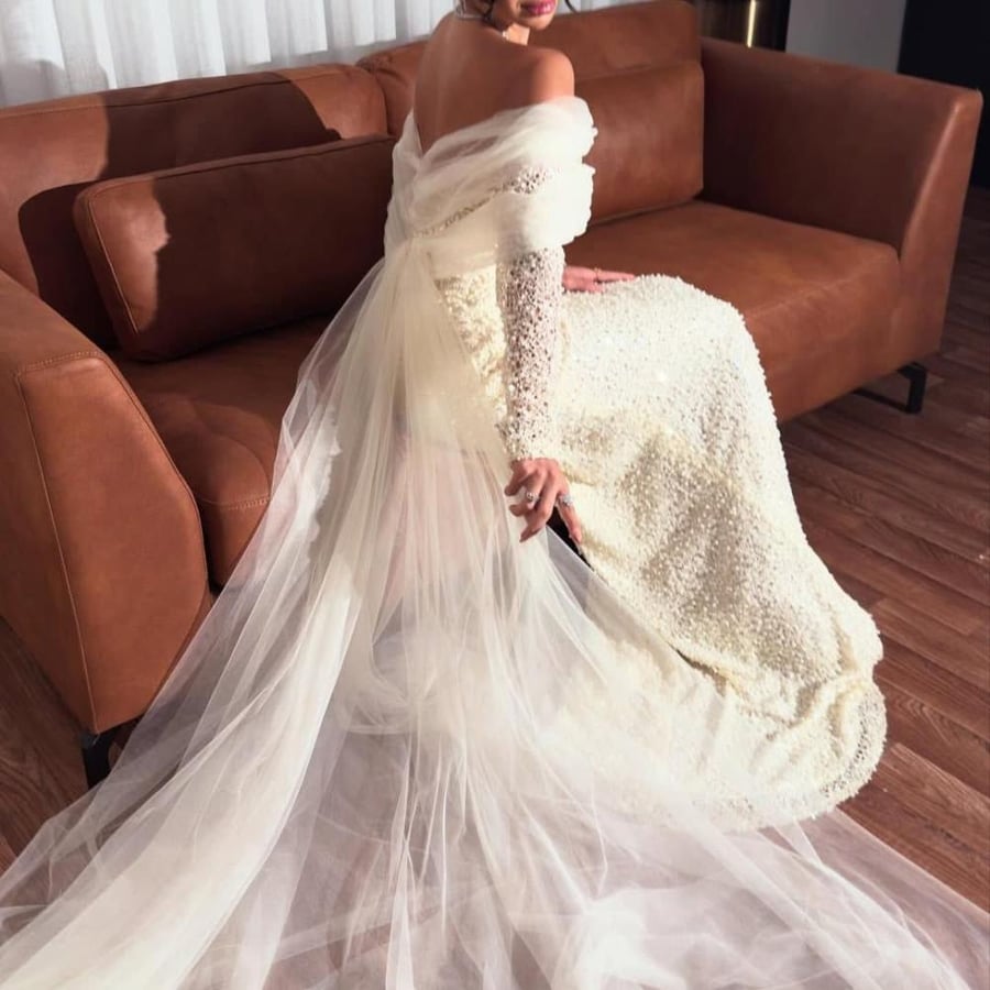 Elegant evening dress adorned with crystals with a stylish chiffon train