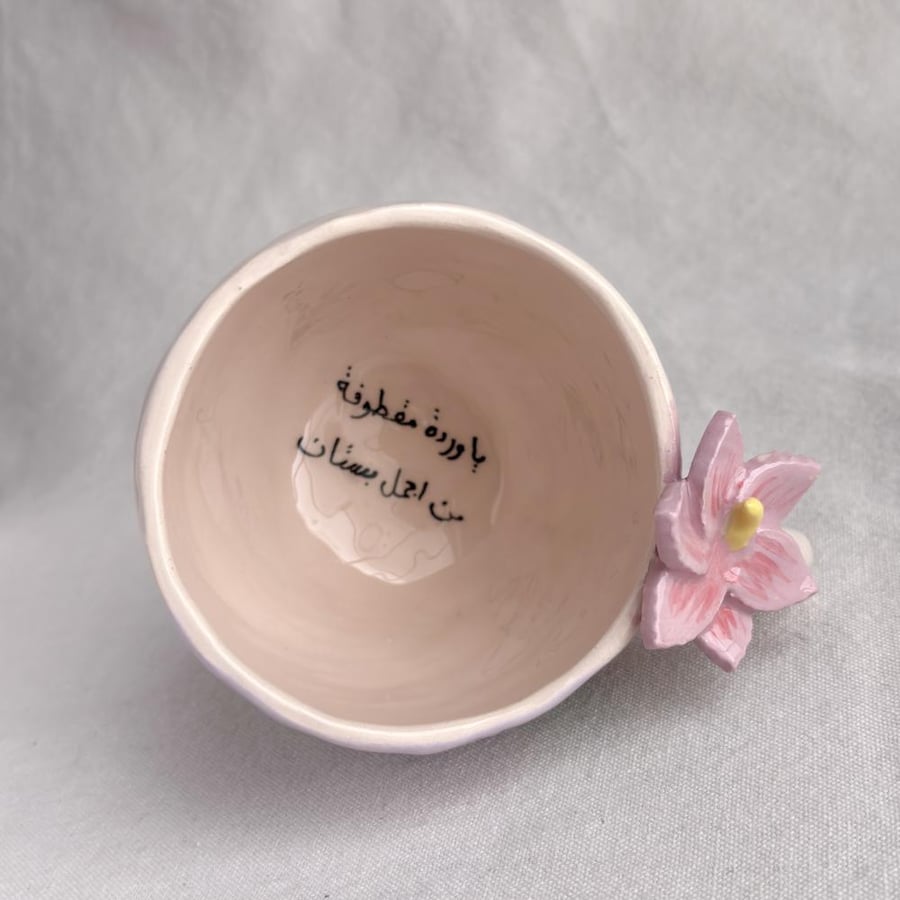 A cup with the phrase: (Oh flower plucked from the most beautiful garden)