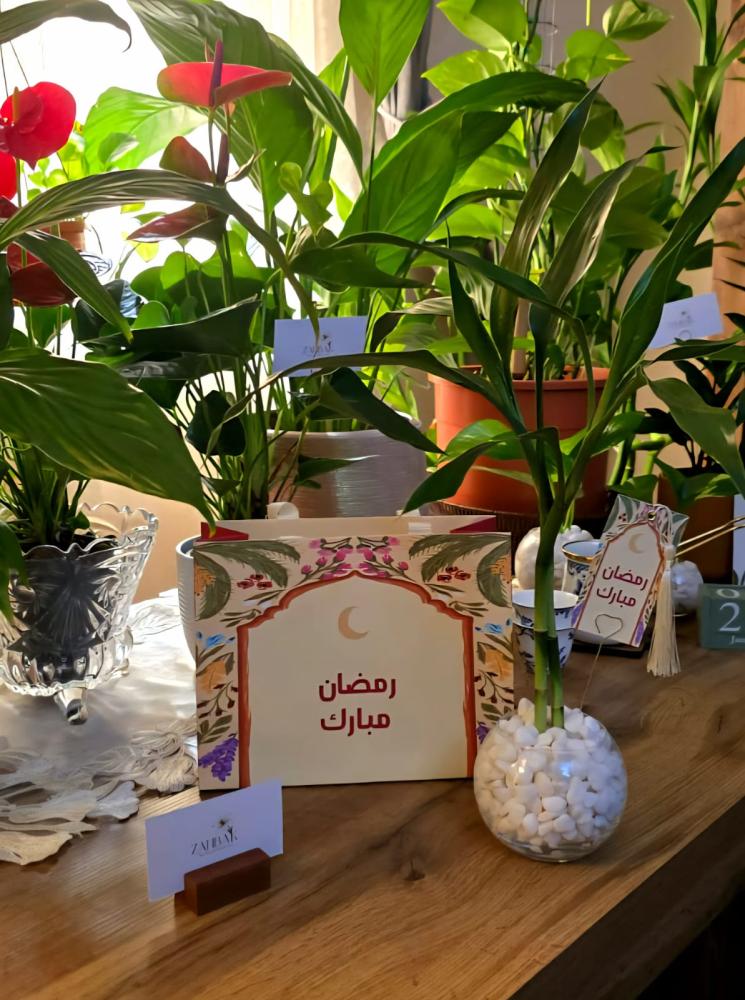 Elegant bamboo plant in a glass office container with a Ramadan Mubarak gift bag