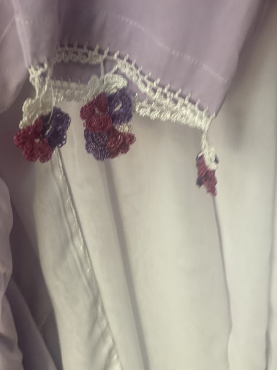 A mauve prayer sheet with an off-white crochet scarf