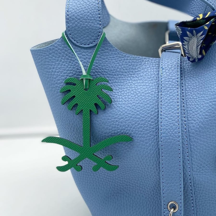 A pendant of two swords and a palm tree