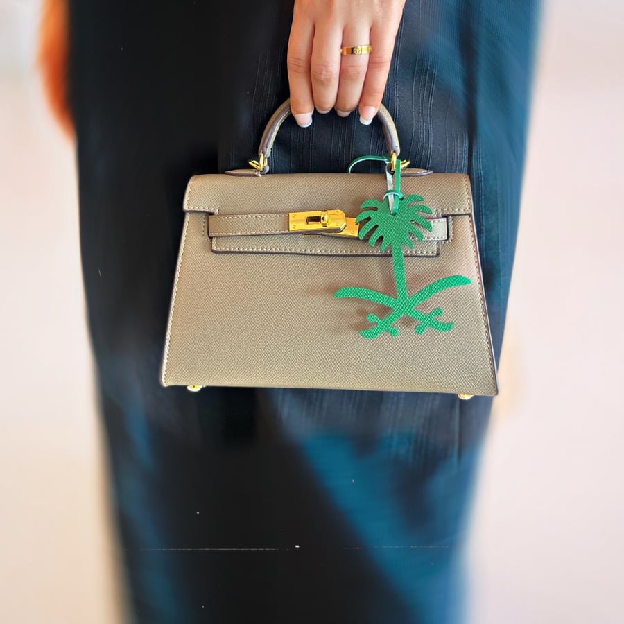 A pendant of two swords and a palm tree