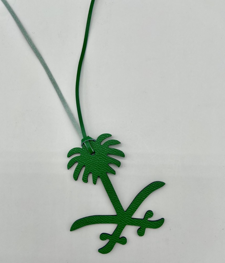 A pendant of two swords and a palm tree