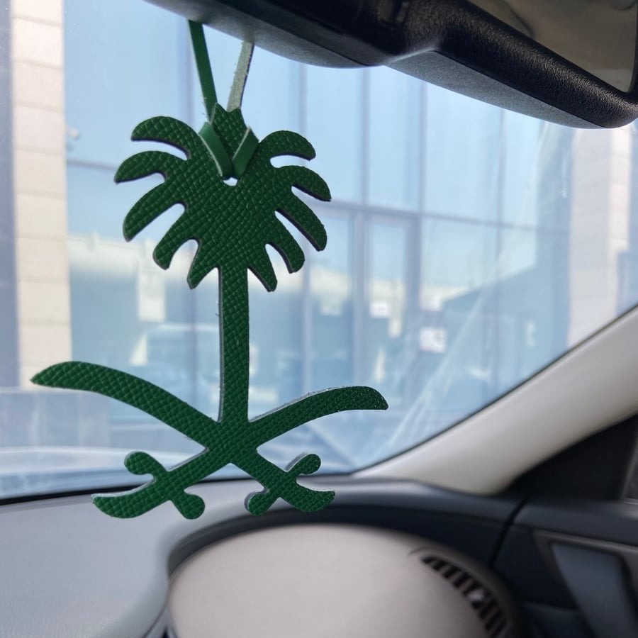 A pendant of two swords and a palm tree