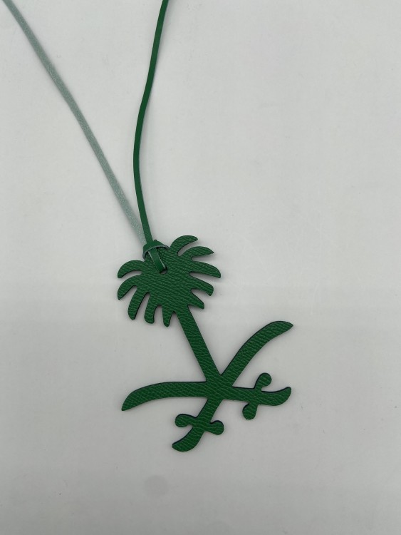 A pendant of two swords and a palm tree