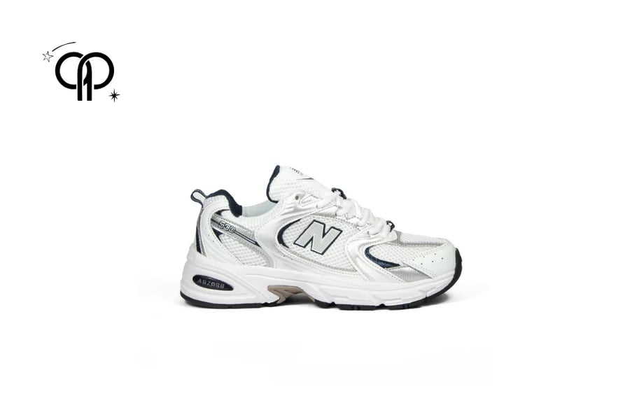 حذاء نيوبالانس ابيض  مع فضي pair of New Balance 530 sneakers in a white and silver colorway.
