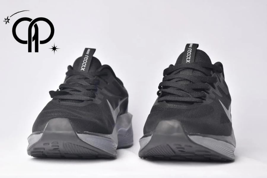 نايكي رياكت اكس اسود a Nike Revolution 7 road running shoe in the black/off-noir colorway.