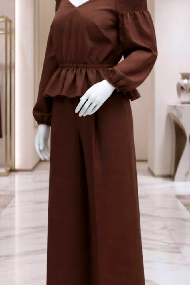 طقم انيق موديل [ 22758 ] بلون بني داكن الذي يمنحك حضوراّ استثنائياّ , بتصميم كتاف مكشوفة ساحر , مع اكمام طويلة منفوشة تضفي لمسة فخامة , تبرز الخصر باناقة , بنطلون واسع الساقين بتصميم عصري رحب