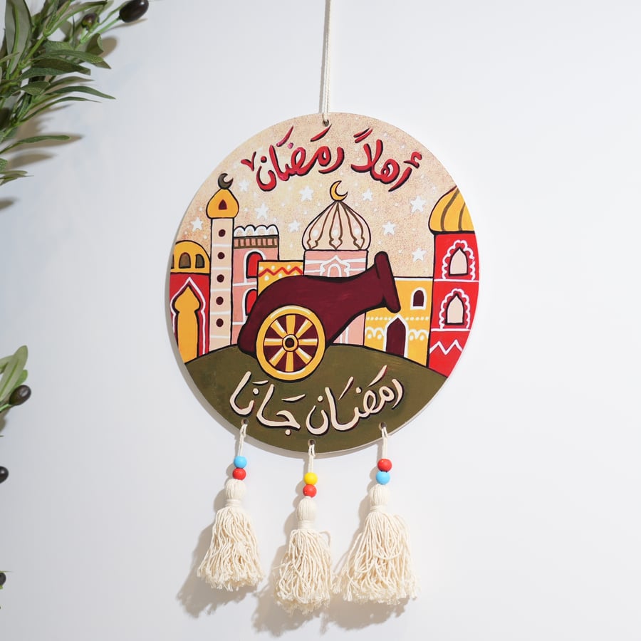 تعليقة رمضانية دائرية بتصميم مدفع رمضان وعبارة رمضان جانا