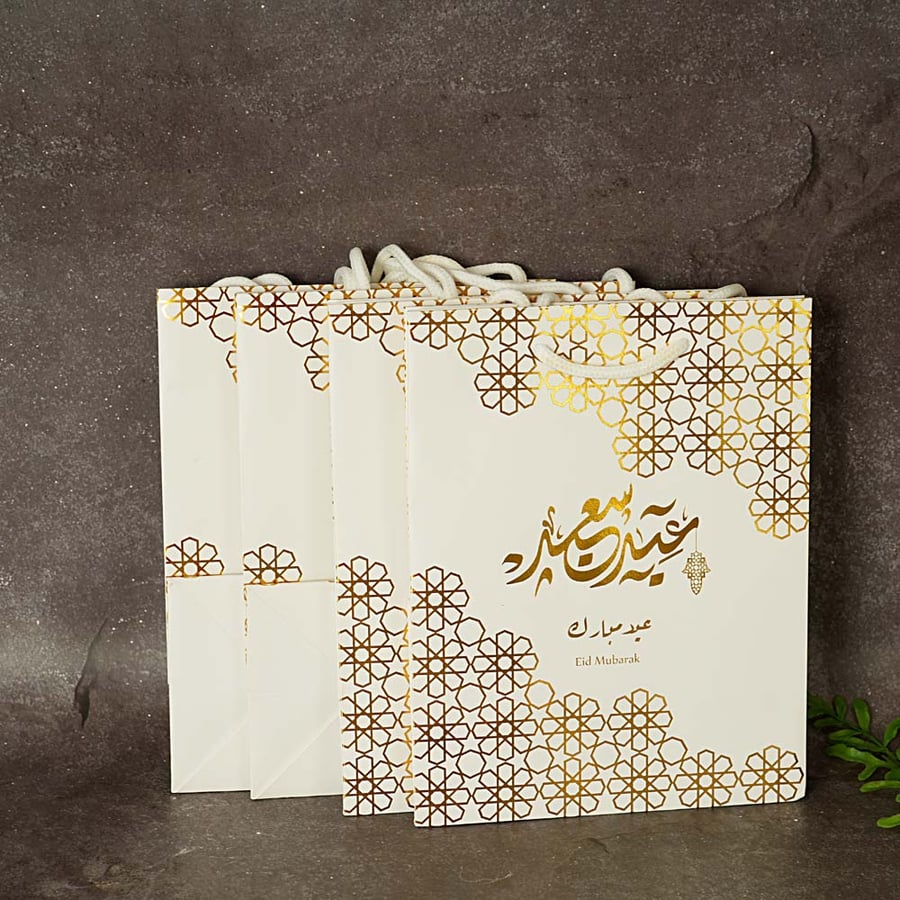 حقيبة توزيعات مزينة بنقوشات ذهبية و عبارة ( عيد سعيد ) باللون الابيض 4 حبة - عيد الفطر 2024