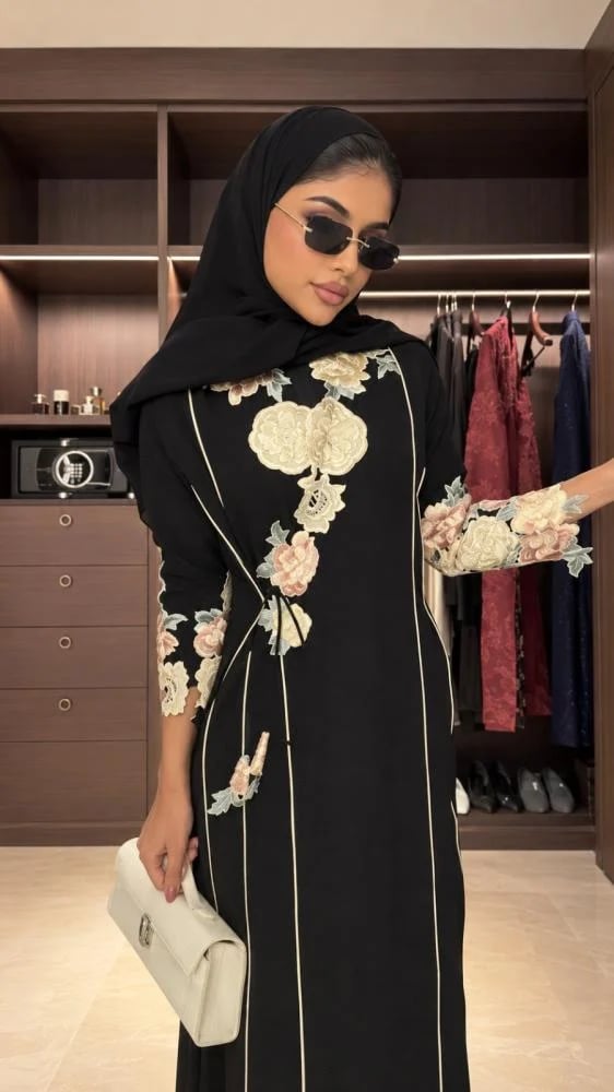 عباية سوداء مزينة بتطريز ورد ملون وفاتح على الصدر والأكمام