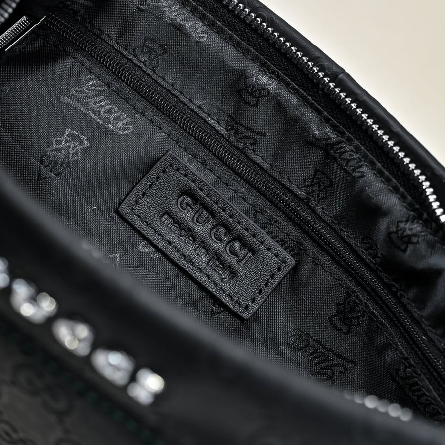 حقيبة كلتش Pouch غوتشي جلدية منقوشة بشعار GG باللون الأسود