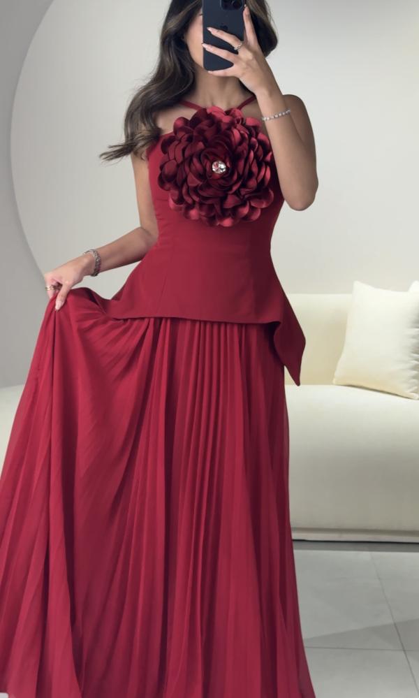 Long dress with pleats, designed with a flower on the chest