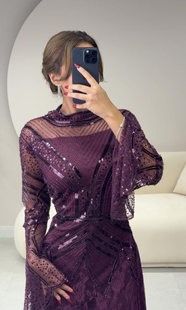 Long purple dress with embroidery on the chest and sleeves, and lace details at the bottom