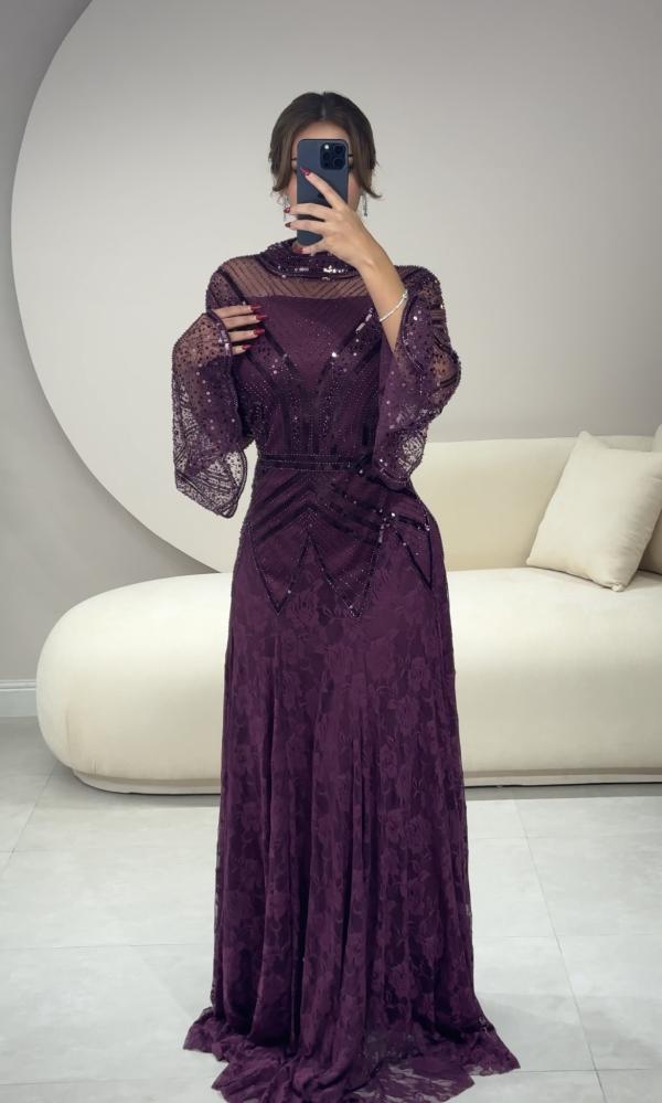 Long purple dress with embroidery on the chest and sleeves, and lace details at the bottom
