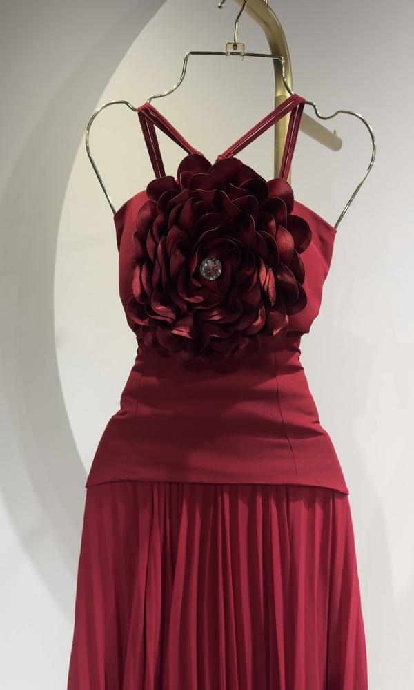 Long dress with pleats, designed with a flower on the chest