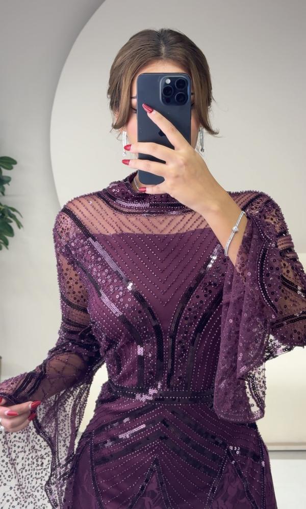 Long purple dress with embroidery on the chest and sleeves, and lace details at the bottom