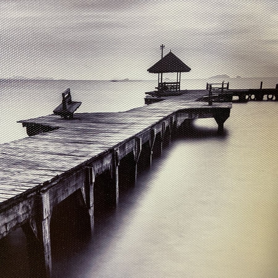 A fabric painting of a wooden bridge on the sea