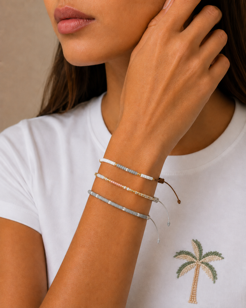 Bracelets made of threads and beads in gold, silver, and gray