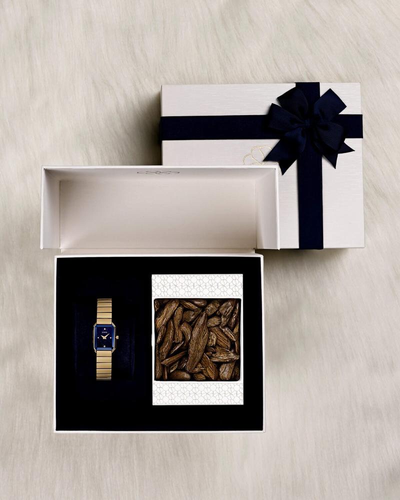 A luxurious women's gift: a gold-tone watch and a fine oud chip.