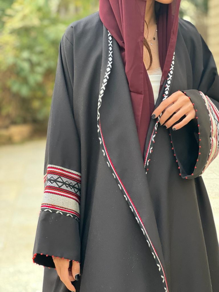 عباية اللون اسود محددة بقماش سدو وعلى والاكمام شك احمر