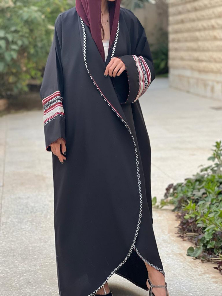 عباية اللون اسود محددة بقماش سدو وعلى والاكمام شك احمر