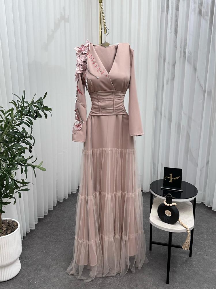 Elegant and soft dress in a nude color with a pinkish tint, decorated with embroidery on the shoulder, long sleeves, with a wide belt at the waist to shape the body, made of Barbie fabric and tulle from Jawhara store
