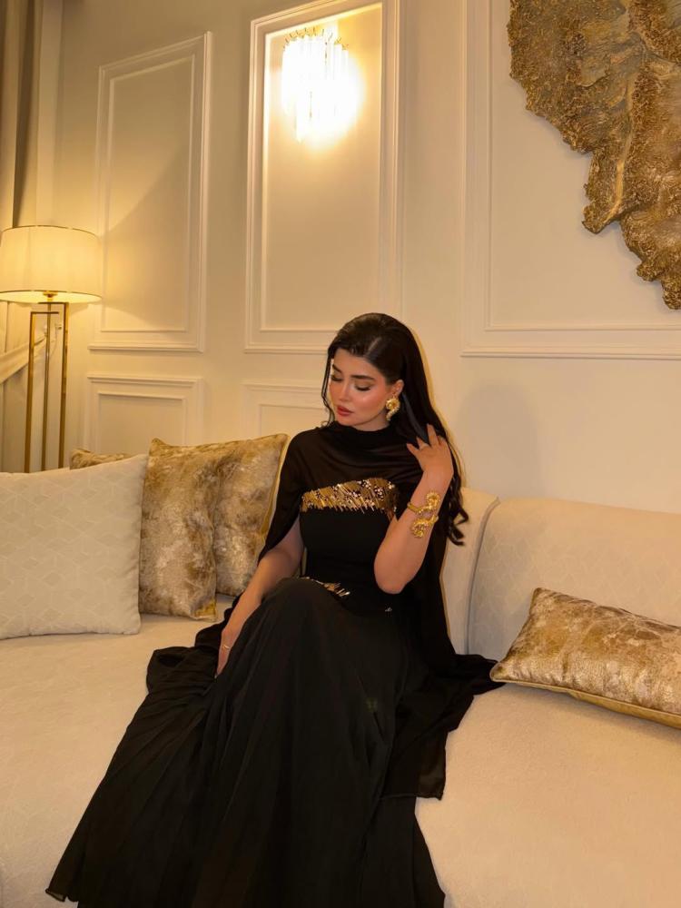 فستان سهره اللون اسود قماش جورجيت مبطن دبل كلوش  بوليسيه  تطريز يدوي باللون الذهبي  شال جورجيت مسكر من الخلف وفيه فتحت رقبه-باربي    من متجر  جوهرهKN  HR  NW