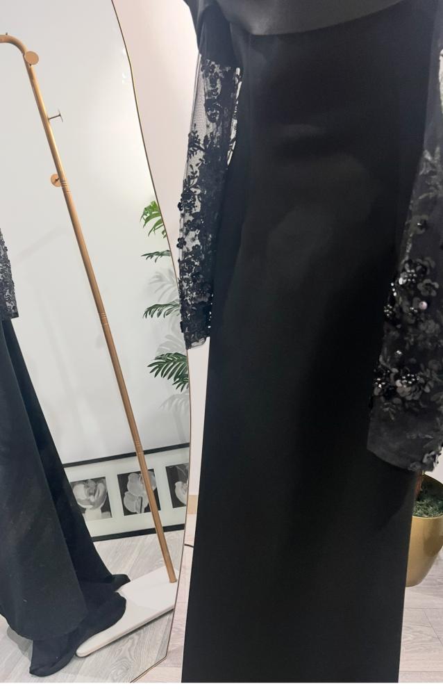 فستان أسود طويل بأكمام مزينة بتطريز وكلفة ورباط عند العنق