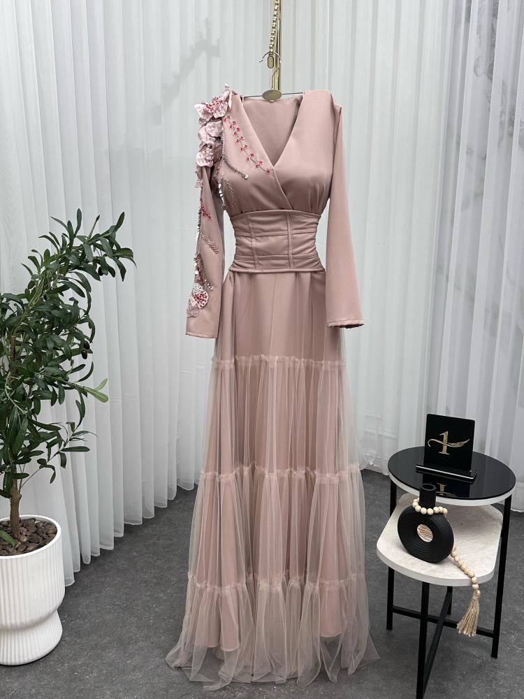 Elegant and soft dress in a nude color with a pinkish tint, decorated with embroidery on the shoulder, long sleeves, with a wide belt at the waist to shape the body, made of Barbie fabric and tulle from Jawhara store