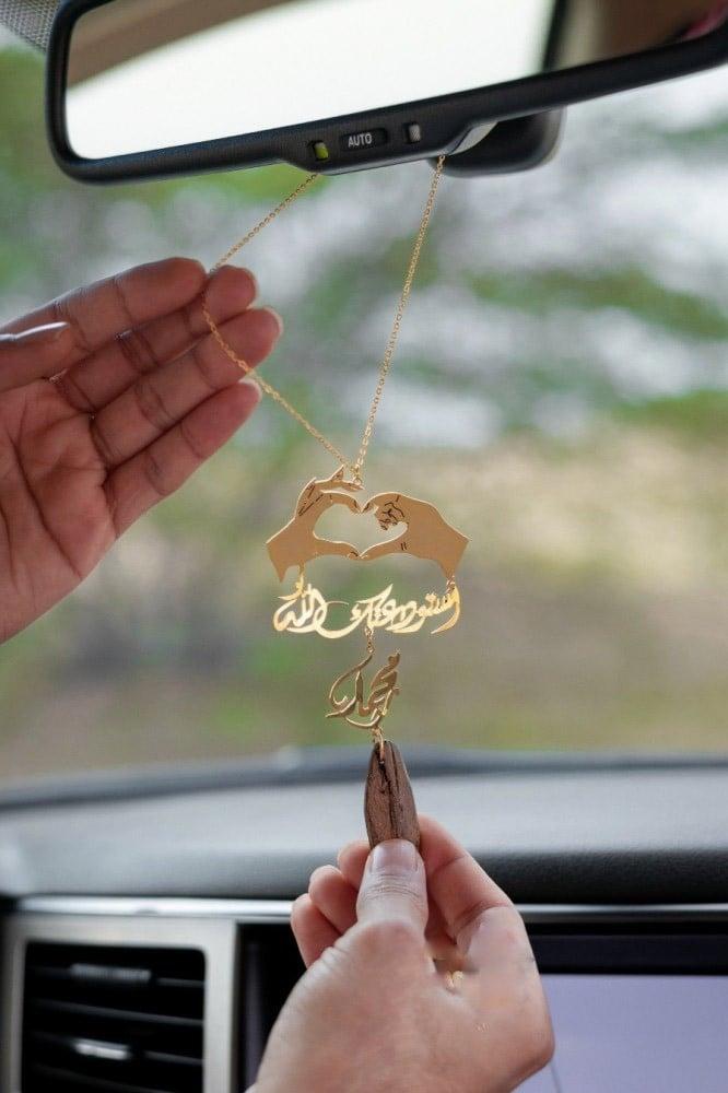 تعليقة السيارة بشكل يدين قلب