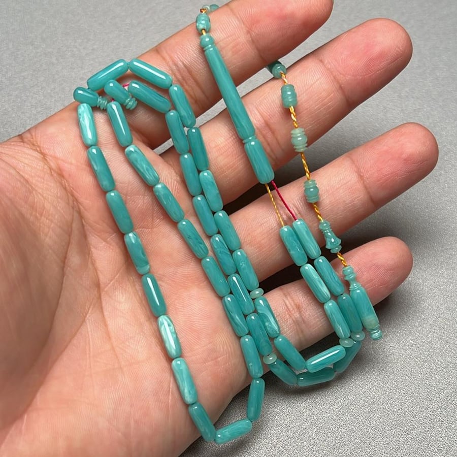 A prayer bead with a clasp made of measuring sticks