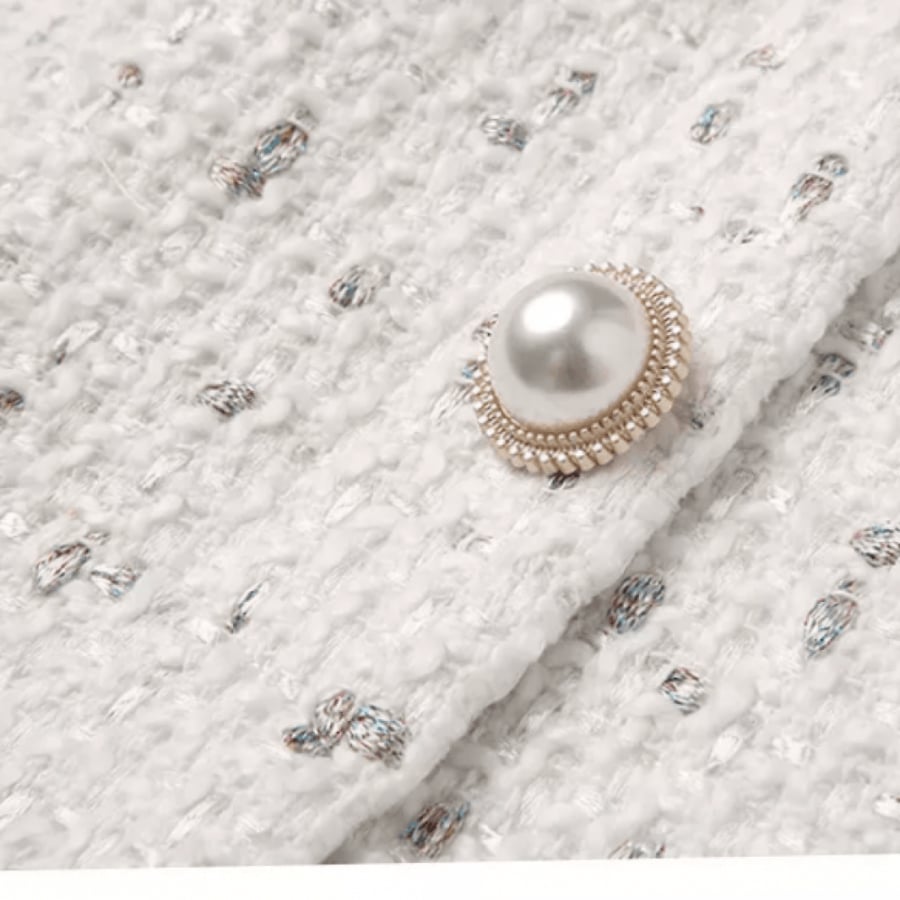 Chanel dress in pearl color embroidered with gold straw and a prominent bow on the collar decorated with pearl buttons and a belt