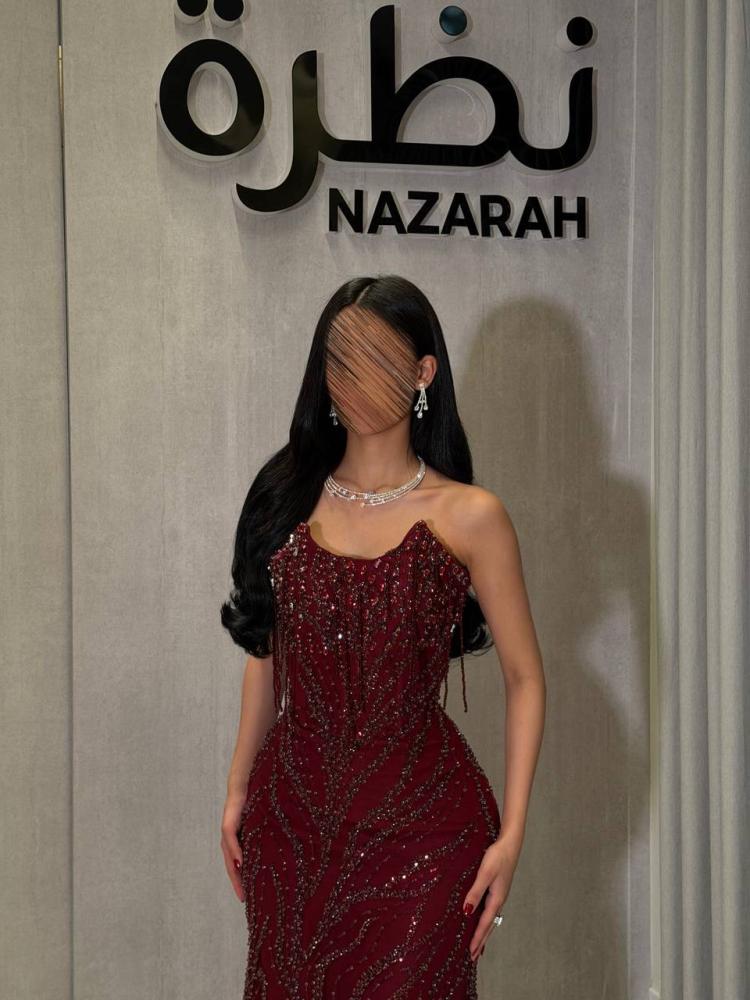 فستان سهرة ، بتطريزات لامعة ونقوش متموجة على كامل الفستان، مع أطراف من التل الشفاف
