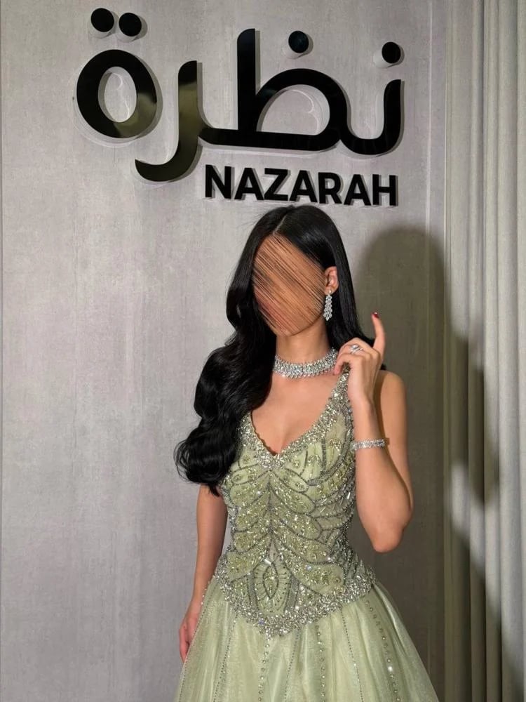 فستان سهرة بقصة كورسيه مطرزة بالخرز والترتر، وجزء سفلي واسع من التول اللامع.