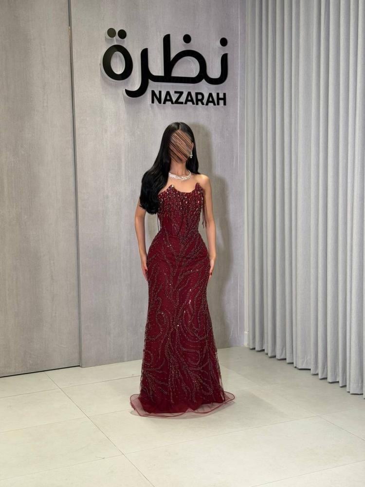 فستان سهرة ، بتطريزات لامعة ونقوش متموجة على كامل الفستان، مع أطراف من التل الشفاف
