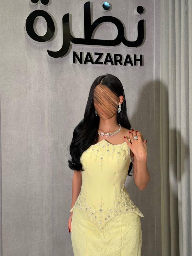 فستان سهرة بقصة كورسيه مطرزة بالخرز، وقماش دانتيل بذيل ممتد.