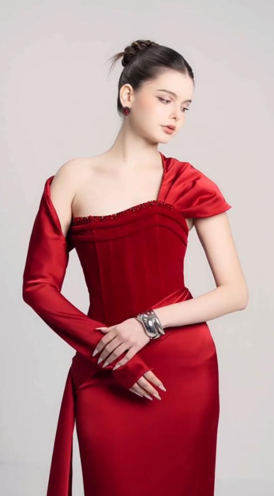 Luxurious red dress with a tight fit that highlights the figure, with an asymmetrical design combining a long sleeve and smooth satin draping on the side. Its beauty is completed by an elegant train that gives a strong presence and a luxurious touch to up